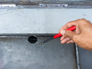 Using welding inspection mirror for check visual welding defects in a niche.