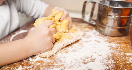 dough in flour kneading childrens hands. cooking concept. on the kitchen.household help. food preparation