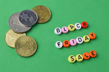 Selective focus of coins and colorful alphabet beads with text BLACK FRIDAY SALE. Business concept.