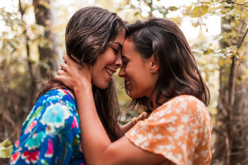 Fototapeta premium Two young lesbians caressing each other in the woods
