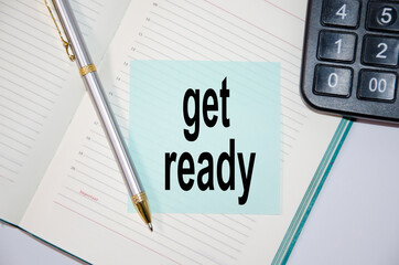 get ready text is written on a blue sticker glued to a notebook with a pen