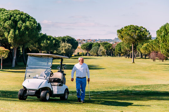 Golf cart on the course with angry senior golfer holding golf club