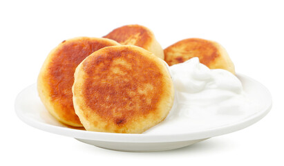 Cheese pancake in a plate with sour cream close-up on a white. Isolated