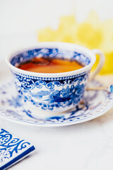 A cup of lemon tea with anise star, white and blue dishes. Copy space