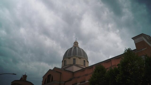 Clouds moving fast behind the dome of an Italian church at afternoon TIMELAPSE