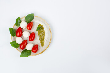 Mozzarella cheese, cherry tomatoes and basil leaves in composition