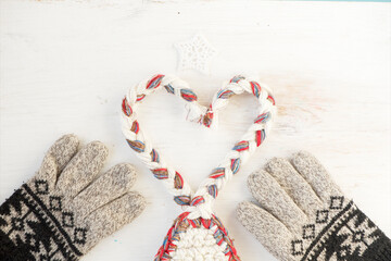 Knitted gloves with a winter pattern and a heart with threads