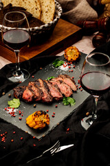 delicious roasted beef with red wine on a wood table background in the restaurant