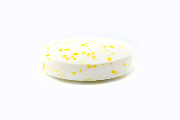 A macro background made of a single white candy with yellow spots.