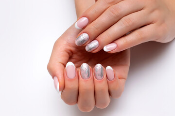 Wedding french white manicure with silver decor, matte foil on short oval nails close-up on a white background.
