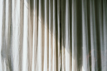 Old gray canvas curtains with sunlight and shadow shading on. Home decoration in minimal style.