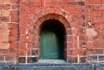 A small pass-through window is set in a brick wall.