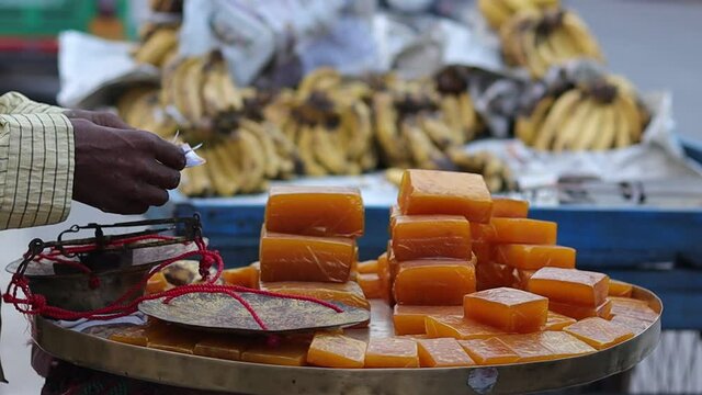 Close up shot of Aam papad, an Indian fruit leather made out of mango pulp mixed with concentrated sugar with selective focus. a mango made sweet is being sold on the streets of Varanasi.