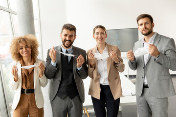 Portrait of young business people taking off their protective face masks
