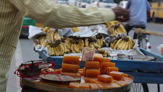 Close up shot of Aam papad, an Indian fruit leather made out of mango pulp mixed with concentrated sugar with selective focus. a mango made sweet is being sold on the streets of Varanasi.