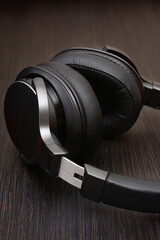 Professional wireless headphones close-up. Against the dark wood countertop
