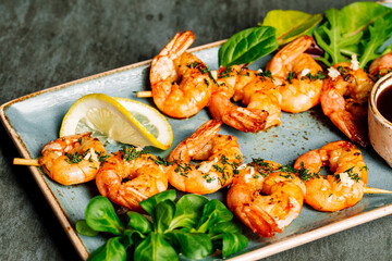 Delicious roasted shrimps on plate with lemon