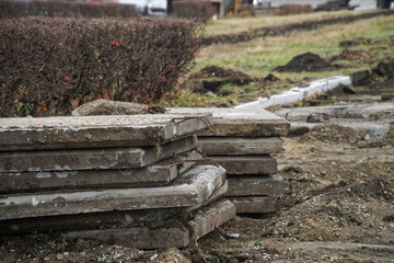 Old reinforced concrete slabs dismantled and prepared for shipment on a path in a city park