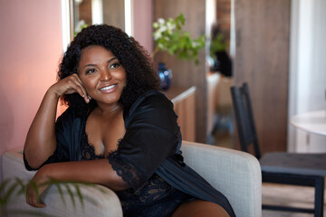 Fototapeta premium beautiful african woman enjoy sitting on armchair, have rest at home. leisure time