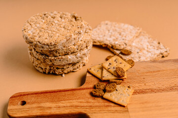Fototapeta premium Various types of healthy whole grain crispbreads and cookies on a brown cozy background on a wooden Board.
