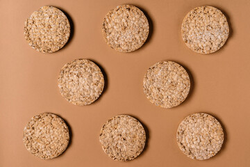 Pattern of healthy whole grain crispbreads on a brown background, photo taken from above