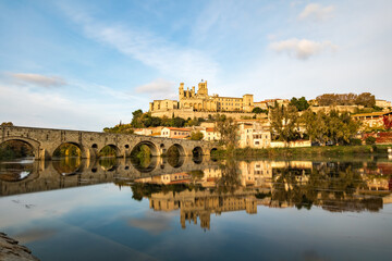 Obraz premium Vue depuis les rives de l'Orb sur la cathédrale Saint-Nazaire de Béziers au coucher du soleil (Occitanie, France)