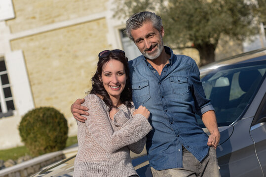 Portrait Of Happy Wealthy Middle Age Couple Outside Of Their House