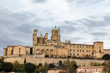 Fototapeta premium Vue depuis les rives de l'Orb sur la cathédrale Saint-Nazaire de Béziers au coucher du soleil (Occitanie, France)