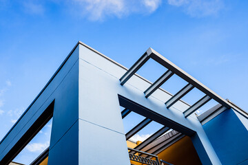 Naklejka premium Roof of a blue painted straight design building behind a clear and clear sky at sunset.