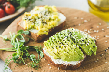 Avocado toast with sesame seeds on wooden board. Healthy appetizer, snack or breakfast with avocado slices