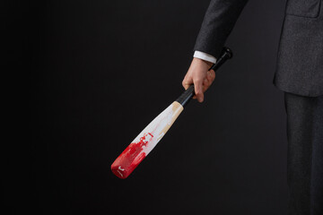 Businessman holding bloody baseball bat
