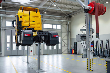 Truck on a lift in a car service. Servicing and repairing trucks in a large garage. Dump trucks and trucks in the hangar for diagnostics