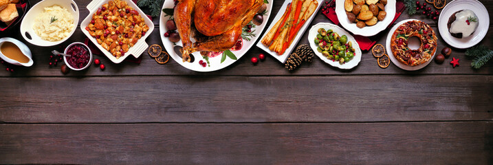 Classic Christmas turkey dinner. Overhead view top border on a dark wood banner background with...