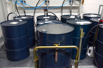 Blue metal barrels with gasoline, oil in a warehouse, close-up