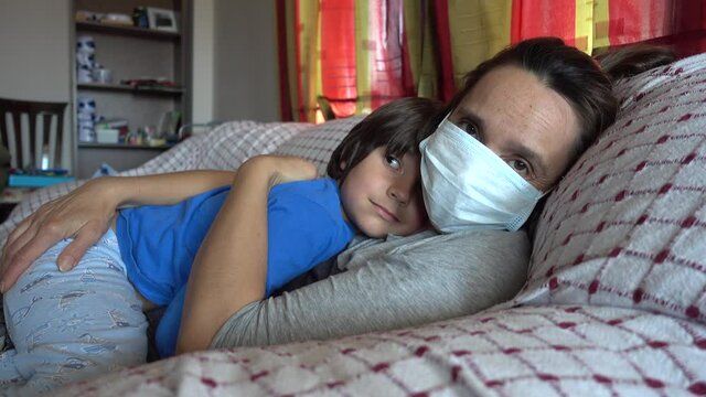 4K Mother in face mask cuddles fer son in Covid lockdown
