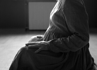 Black and white photo of pregnant woman. Belly of a pregnant girl. Woman hands hugging pregnant belly. Parenthood and motherhood.