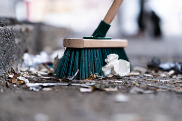 Closeup of a green street broom used in cleaning a cobblestone street