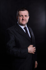 Middle aged solid man dressed in suit studio portrait