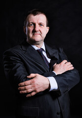 Middle aged solid man dressed in suit studio portrait