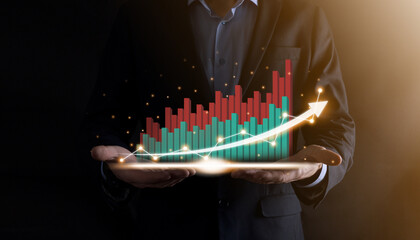 Businessman holding and showing a growing virtual hologram of statistics, graph and chart with arrow up on dark background. Stock market. Business growth, planing and strategy concept.