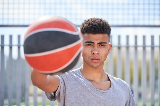 Young Determined African American Male Player Standing With Basketball On Sports Ground And Looking At Camera