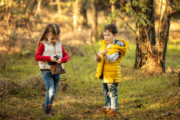 cute boy and girl 4 years old play with an old film camera and take pictures of each other © Arina Makarenko