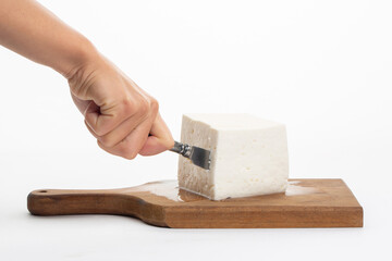 Woman cut white cheese on white background