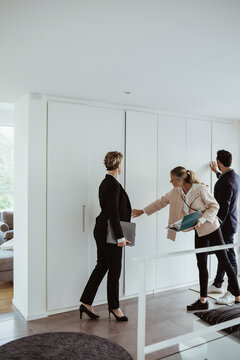 Real estate agent showing property to male and female at new house