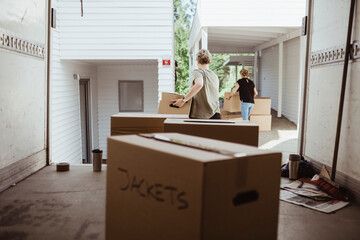 Female friends carrying cardboard boxes during relocation