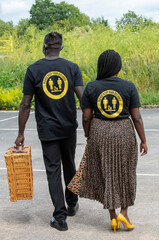 Hampshire, England, UK. 2020, Couple wearing Please Keep your Distance shirts hand in hand taking a walk.