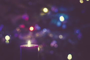 christmas festive concept with christmas tree lights and burning candle