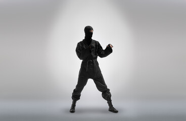 japanese ninja in black uniform, on grey background