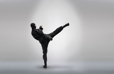japanese ninja in black uniform, on grey background - obrazy, fototapety, plakaty