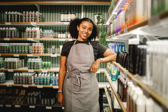 Portrait of smiling saleswoman standing in supermarket